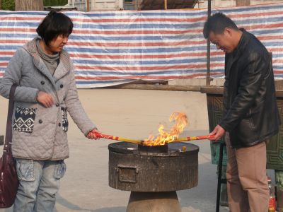 Personnes brûlant de l'encens dans le temple bouddhiste